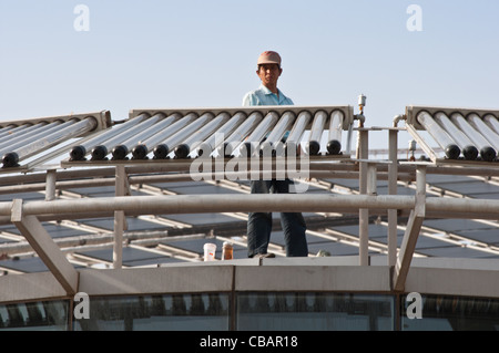 Ein Arbeiter auf dem Dach des Micro-E Hotels, weltweit größte solar betriebene Hotel. China Solar Valley, Dezhou, Shandong, China Stockfoto