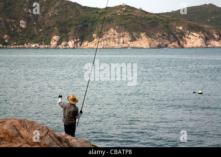 Mann Angeln auf den Felsen von Tung Wan Strand, Cheung Chau, Hong Kong abgelegenen Insel SAR China Stockfoto