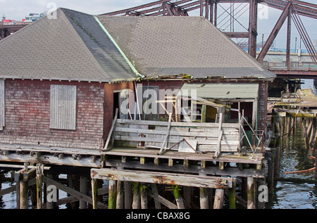 rustikale alte Fischerei-Hütte am dock im Hafen von Boston vor verwitterte rostige Brücke Stockfoto