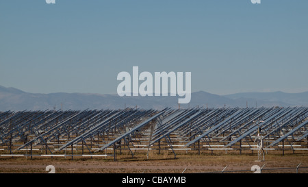 Eine Reihe von großen Solaranlagen bildet eine symmetrische Leitung in einem Kraftwerk in der San Luis Valley von zentraler Colorado. Diese Platten verwenden ein Tracking System, um der Sonne zu folgen, sammelt seine Energie und mit Solarzellen das Sonnenlicht in Strom zu verwandeln. Stockfoto