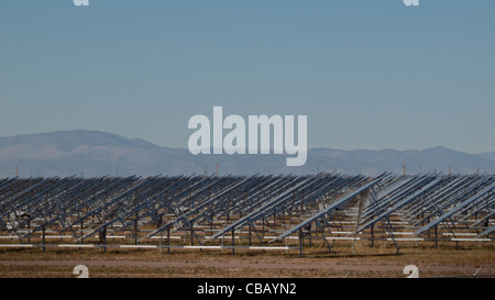 Eine Reihe von großen Solaranlagen bildet eine symmetrische Leitung in einem Kraftwerk in der San Luis Valley von zentraler Colorado. Diese Platten verwenden ein Tracking System, um der Sonne zu folgen, sammelt seine Energie und mit Solarzellen das Sonnenlicht in Strom zu verwandeln. Stockfoto