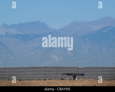 Eine Reihe von großen Solaranlagen bildet eine symmetrische Leitung in einem Kraftwerk in der San Luis Valley von zentraler Colorado. Diese Platten verwenden ein Tracking System, um der Sonne zu folgen, sammelt seine Energie und mit Solarzellen das Sonnenlicht in Strom zu verwandeln. Stockfoto