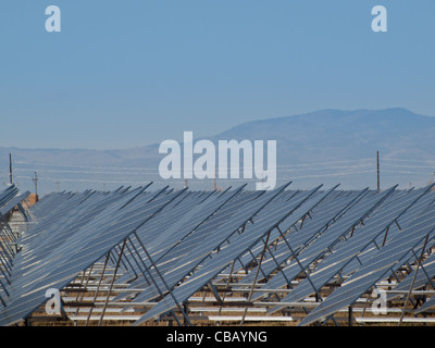 Eine Reihe von großen Solaranlagen bildet eine symmetrische Leitung in einem Kraftwerk in der San Luis Valley von zentraler Colorado. Diese Platten verwenden ein Tracking System, um der Sonne zu folgen, sammelt seine Energie und mit Solarzellen das Sonnenlicht in Strom zu verwandeln. Stockfoto