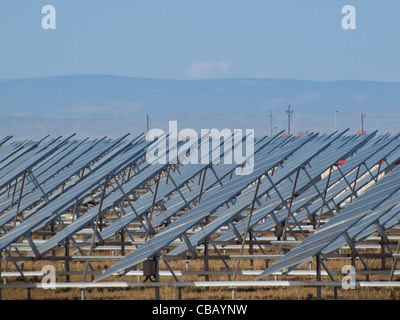 Eine Reihe von großen Solaranlagen bildet eine symmetrische Leitung in einem Kraftwerk in der San Luis Valley von zentraler Colorado. Diese Platten verwenden ein Tracking System, um der Sonne zu folgen, sammelt seine Energie und mit Solarzellen das Sonnenlicht in Strom zu verwandeln. Stockfoto