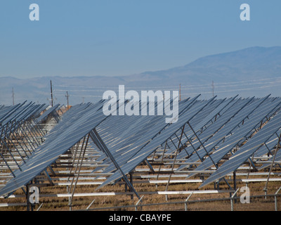 Eine Reihe von großen Solaranlagen bildet eine symmetrische Leitung in einem Kraftwerk in der San Luis Valley von zentraler Colorado. Diese Platten verwenden ein Tracking System, um der Sonne zu folgen, sammelt seine Energie und mit Solarzellen das Sonnenlicht in Strom zu verwandeln. Stockfoto