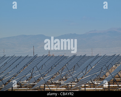 Eine Reihe von großen Solaranlagen bildet eine symmetrische Leitung in einem Kraftwerk in der San Luis Valley von zentraler Colorado. Diese Platten verwenden ein Tracking System, um der Sonne zu folgen, sammelt seine Energie und mit Solarzellen das Sonnenlicht in Strom zu verwandeln. Stockfoto