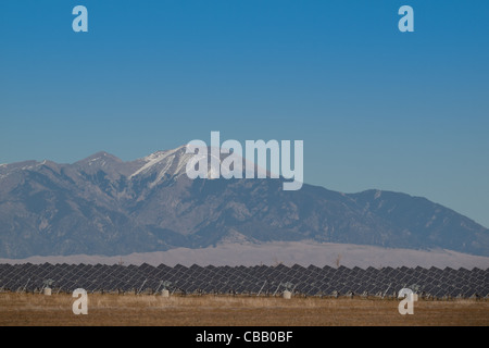 Eine Reihe von großen Solaranlagen bildet eine symmetrische Leitung in einem Kraftwerk in der San Luis Valley von zentraler Colorado. Diese Platten verwenden ein Tracking System, um der Sonne zu folgen, sammelt seine Energie und mit Solarzellen das Sonnenlicht in Strom zu verwandeln. Stockfoto