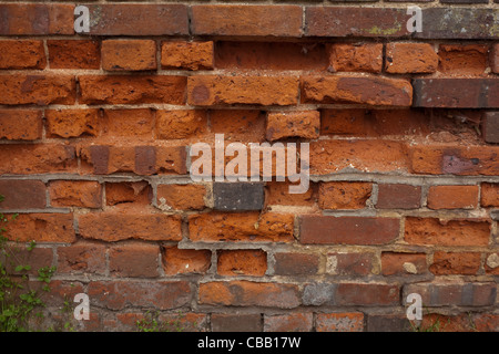 Alte Mauer gebaut aus lokal gebrannter Ton. Aylsham, Norfolk. Stockfoto