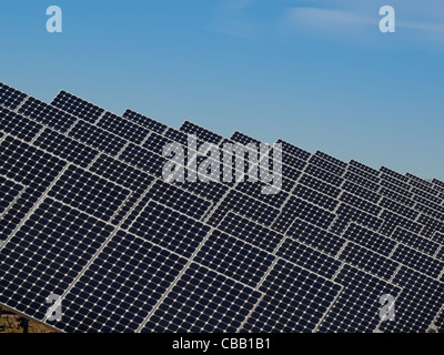 Eine Reihe von großen Solaranlagen bildet eine symmetrische Leitung in einem Kraftwerk in der San Luis Valley von zentraler Colorado. Diese Platten verwenden ein Tracking System, um der Sonne zu folgen, sammelt seine Energie und mit Solarzellen das Sonnenlicht in Strom zu verwandeln. Stockfoto