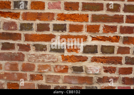Alte Mauer gebaut aus lokal gebrannter Ton. Aylsham, Norfolk. Erneut wies mit Zement. Stockfoto