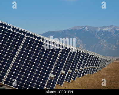 Eine Reihe von großen Solaranlagen bildet eine symmetrische Leitung in einem Kraftwerk in der San Luis Valley von zentraler Colorado. Diese Platten verwenden ein Tracking System, um der Sonne zu folgen, sammelt seine Energie und mit Solarzellen das Sonnenlicht in Strom zu verwandeln. Stockfoto