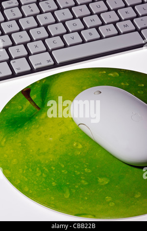 Nahaufnahme von Apple Funkmaus auf einem Mauspad in der Form eines Apfels mit ein Apple wireless Keyboard auf weißem Hintergrund Stockfoto