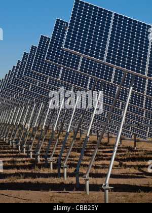 Eine Reihe von großen Solaranlagen bildet eine symmetrische Leitung in einem Kraftwerk in der San Luis Valley von zentraler Colorado. Diese Platten verwenden ein Tracking System, um der Sonne zu folgen, sammelt seine Energie und mit Solarzellen das Sonnenlicht in Strom zu verwandeln. Stockfoto