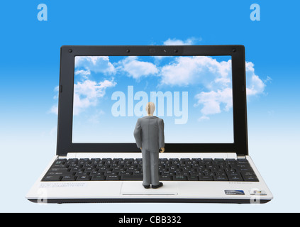 Laptop mit Wolken am Bildschirm und Miniatur Geschäftsmann Stockfoto