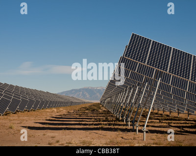 Eine Reihe von großen Solaranlagen bildet eine symmetrische Leitung in einem Kraftwerk in der San Luis Valley von zentraler Colorado. Diese Platten verwenden ein Tracking System, um der Sonne zu folgen, sammelt seine Energie und mit Solarzellen das Sonnenlicht in Strom zu verwandeln. Stockfoto