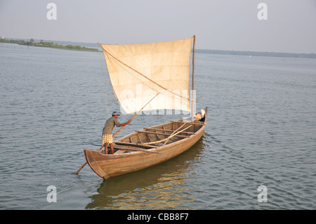 ein Mann, ein Segelboot mit einem Stock in den Backwaters von Kerala, Alapuzha Rudern Stockfoto