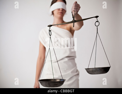 Eine anschauliche Foto von weibliches Modell verkleidet als Justitia, Roman Goddess der Gerechtigkeit und des Rechtssystems, in ihren Händen Sie Stockfoto