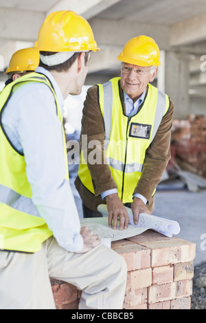 Bauarbeiter, die Baupläne lesen Stockfoto