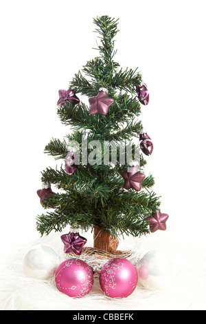 Plastik-Weihnachtsbaum mit lila Sternen und rosa Kugeln isoliert auf weißem Hintergrund Stockfoto