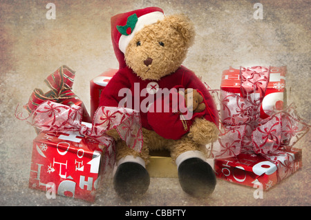 Teddy zu Weihnachten. Geliebten Kindes Teddy gekleidet als Santa sitzt unter präsentiert. Stockfoto