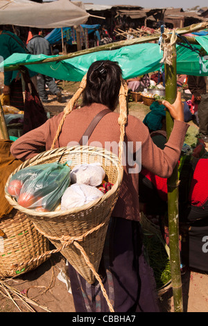 Shillong, Meghalaya, Indien und Jaintia Hills district, Ummulong Bazar, Khasi Frau Carring in konischen Korb kauft Stockfoto