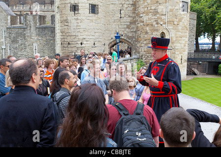 Ein Beefeater Reiseführer auf den Tower of London einen Vortrag, eine Gruppe von Touristen. Stockfoto