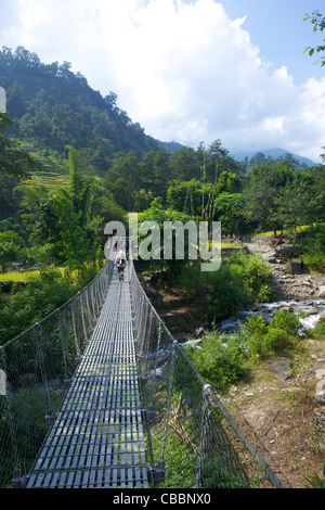 Wanderer durchqueren Aussetzung Brücke über Modi River in der Nähe von Birethanti, Annapurna Sanctuary Region, Himalaya, Nepal, Asien Stockfoto