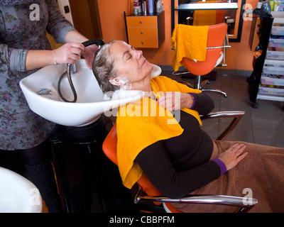 Frau mittleren Alters, die ihr Haar gewaschen in den Friseursalon Stockfoto