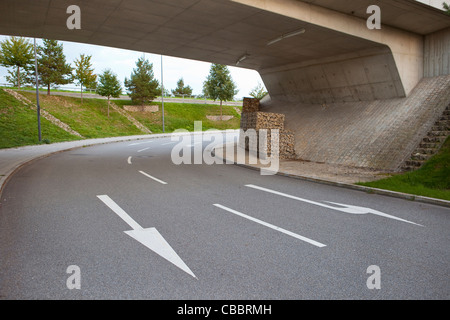 Gemalte Pfeile auf der Straße unter der Brücke Stockfoto