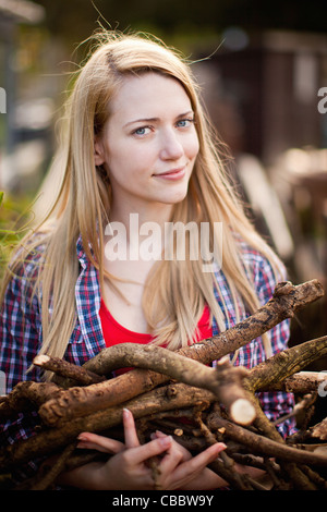 Frau sammeln von Brennholz im Garten Stockfoto