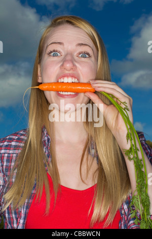 Frau beißende Karotte im freien Stockfoto