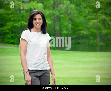 Hübsche Frau, die auf Rasen Porträt draußen Stockfoto