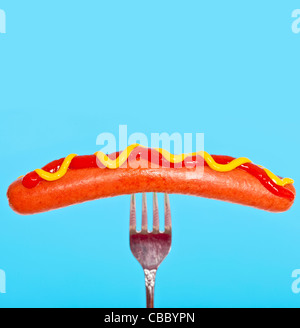 Hot Dog mit Senf und Ketchup auf einer Gabel Stockfoto