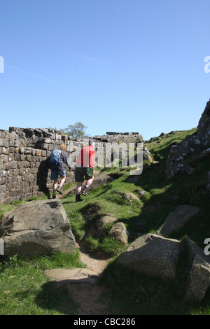 Wanderer zu Fuß entlang Seite Hadrianswall auf Walltown Felsen Stockfoto