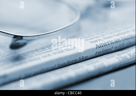 Brille liegen auf einem Stapel Zeitungen. Blau getönt. Ein Foto hautnah. Selektiven Fokus Stockfoto