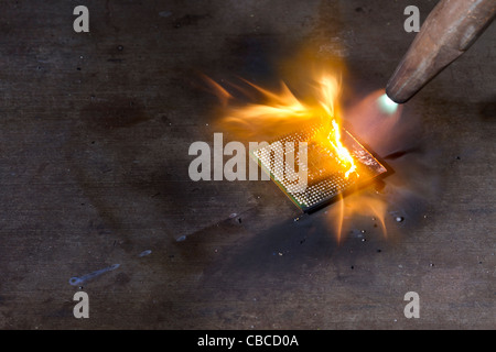 Brennen einer zentralen Recheneinheit auf metallischen Boden mit Schweißbrenner Stockfoto