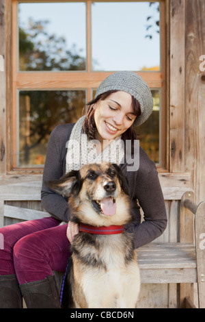 Frau Petting Hund auf Veranda Stockfoto