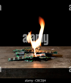 kleine Haufen brennenden RAM-sticks vor dunklen Rücken Stockfoto