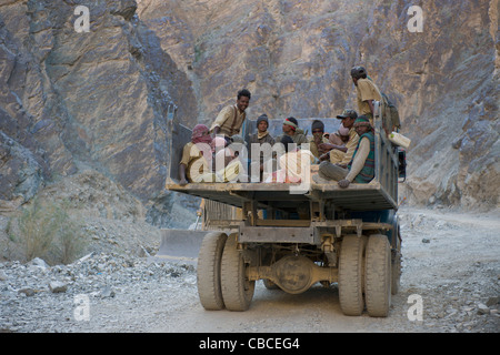 Arbeiter, Reiten auf dem Rücken eines Kipper-LKW auf der Autobahn Srinagar-Leh (Ladakh) Jammu & Kaschmir, Indien Stockfoto