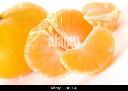Segmente und die ganze Mandarine. Ein Detailfoto von Obst auf weißem Hintergrund Stockfoto