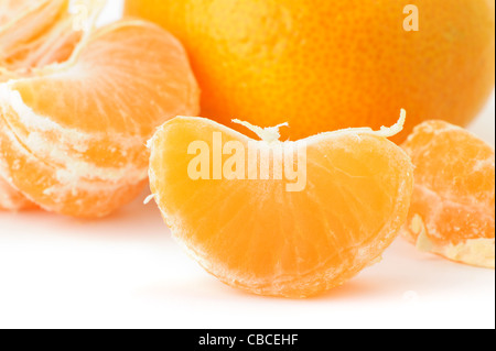 Segmente und die ganze Mandarine. Ein Detailfoto von Obst auf weißem Hintergrund Stockfoto