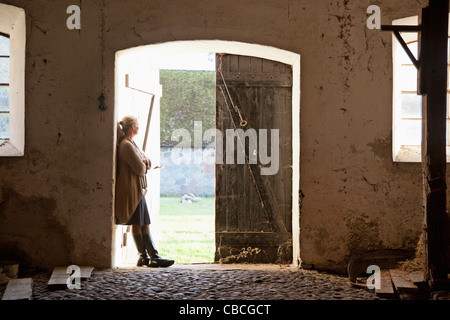 Frau stehend an Scheunentore Stockfoto