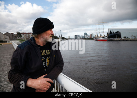 Arbeitslosen erwachsenen Mann über Geländer aus einem Gehweg in Govan, über den Fluss Clyde in die neue Riverside Museum Stockfoto