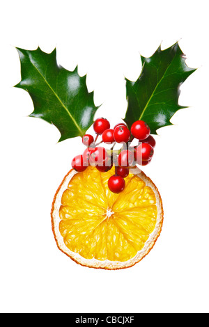 Foto von eine Weihnachts-Dekoration mit Holly, roten Beeren und einem getrockneten Orangenscheibe, isoliert auf einem weißen Hintergrund gemacht. Stockfoto