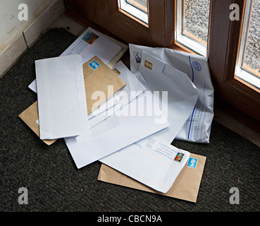 Briefe an Haus in Haufen auf Fußmatte Wales UK geliefert Stockfoto