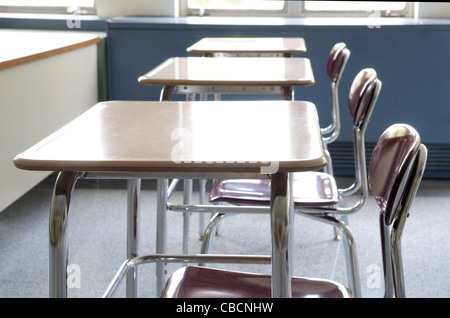 Tische in Reihen in einem leeren Klassenzimmer Stockfoto