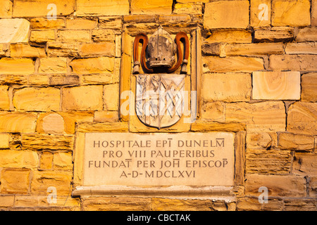 Sightseeing und Sehenswürdigkeiten: Wand Inschrift auf dem Gelände des Krankenhauses ein Armer, einem alten, historischen Gebäude in der Cathedral Square, Durham, 1666 gegründet Stockfoto