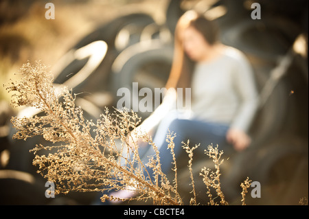 Mädchen sitzt auf einem Haufen von Reifen denken. Stockfoto