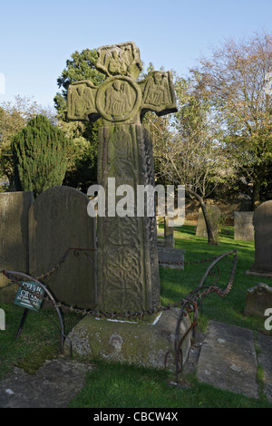 Das sächsische Kreuz aus dem 8. Jahrhundert auf dem Friedhof der St. Lawrence Church, Eyam, Derbyshire, England, ist in der Klasse I aufgeführt Stockfoto