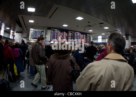 Große Zahl von Menschen im Wartezimmer in der Nähe der Abfahrtstafel in Penn Station, New York City Stockfoto